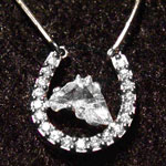 Custom necklace with a horse head cut diamond contained in a platinum horseshoe embedded with 19 smaller diamonds