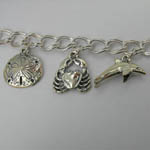 Close up of Sand Dollar and Sea Crab and Dolphin charms on Sea Life bracele