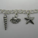 Close up of Conical Shell and Octopus and Sea Star on Nautical Charm Bracel