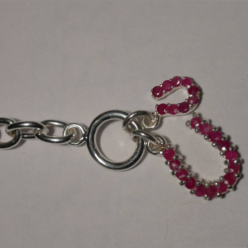 close up of clasp of ruby horseshoe bracelet